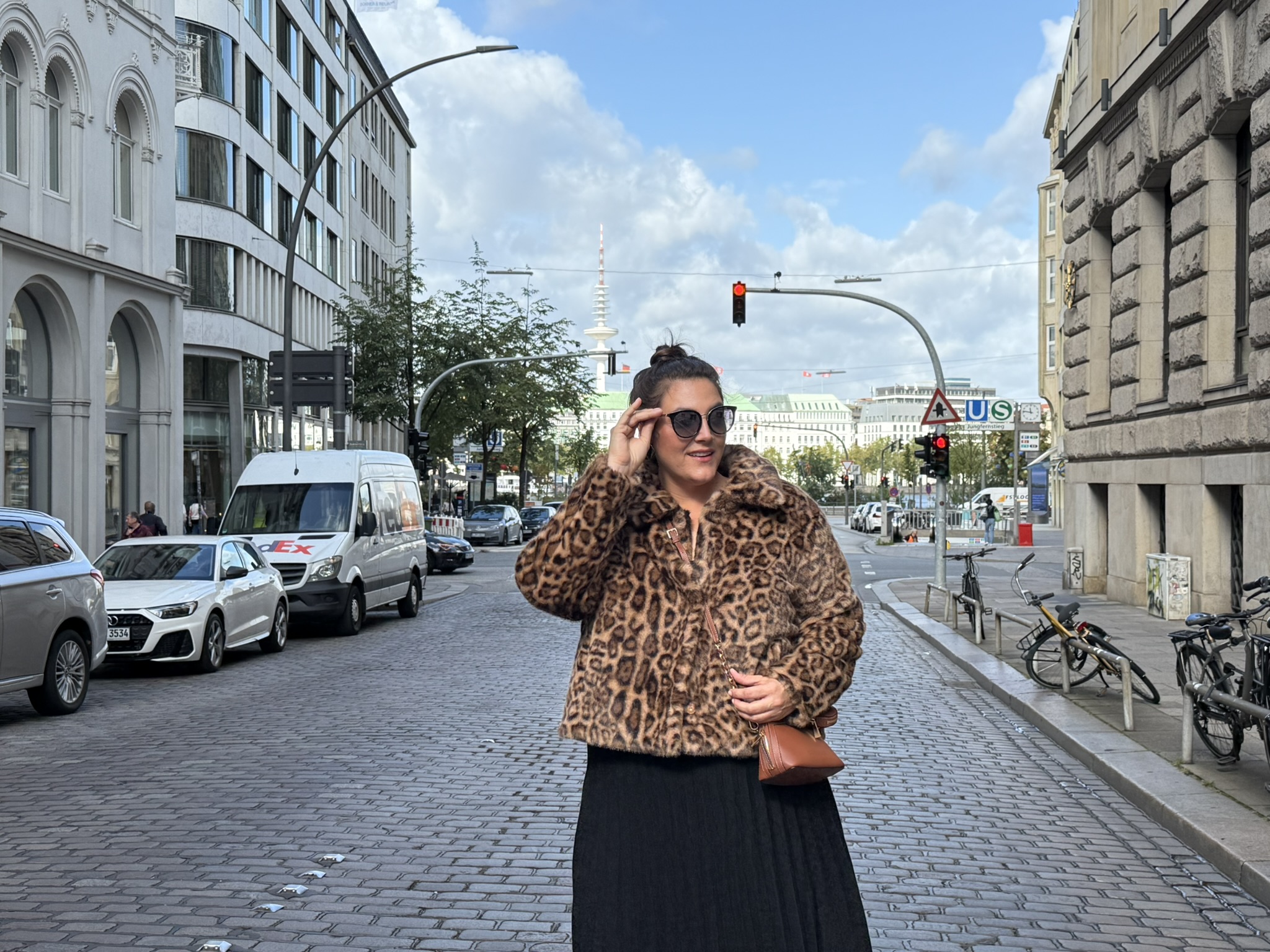 Elegantes Outfit in Felloptik für abendmode große größen bremen, getragen von einer Frau in der Innenstadt auf Kopfsteinpflaster.