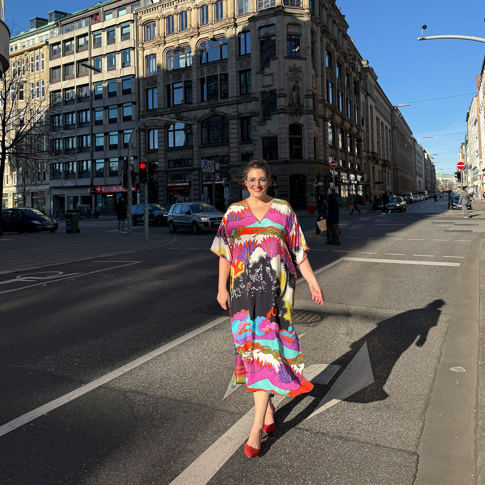 Frau trägt ein farbenfrohes Kleid in der Innenstadt, elegante Damenmode große Größen Nürnberg mit besonderem Muster und lebendigem Stil.