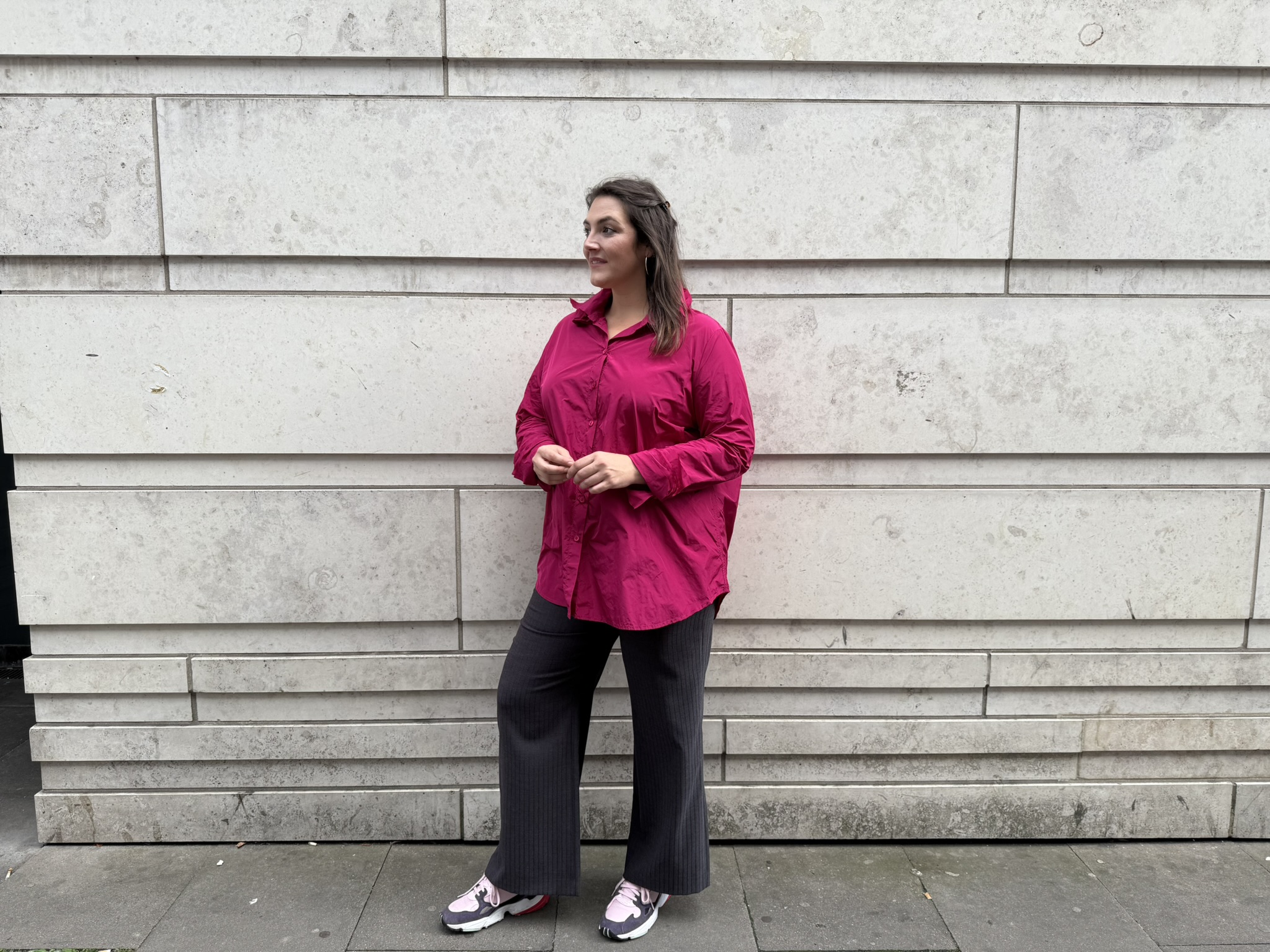 Dresden Damenmode große Größen mit modernem Outfit vor heller Steinwand.