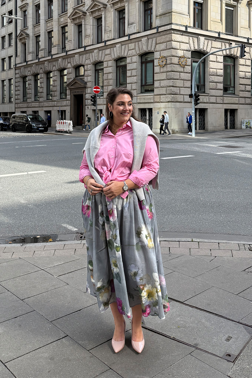 Floral elegantes Outfit mit Midirock und pinker Bluse, präsentiert als Inspiration für Kleider in großen Größen in Mannheim.