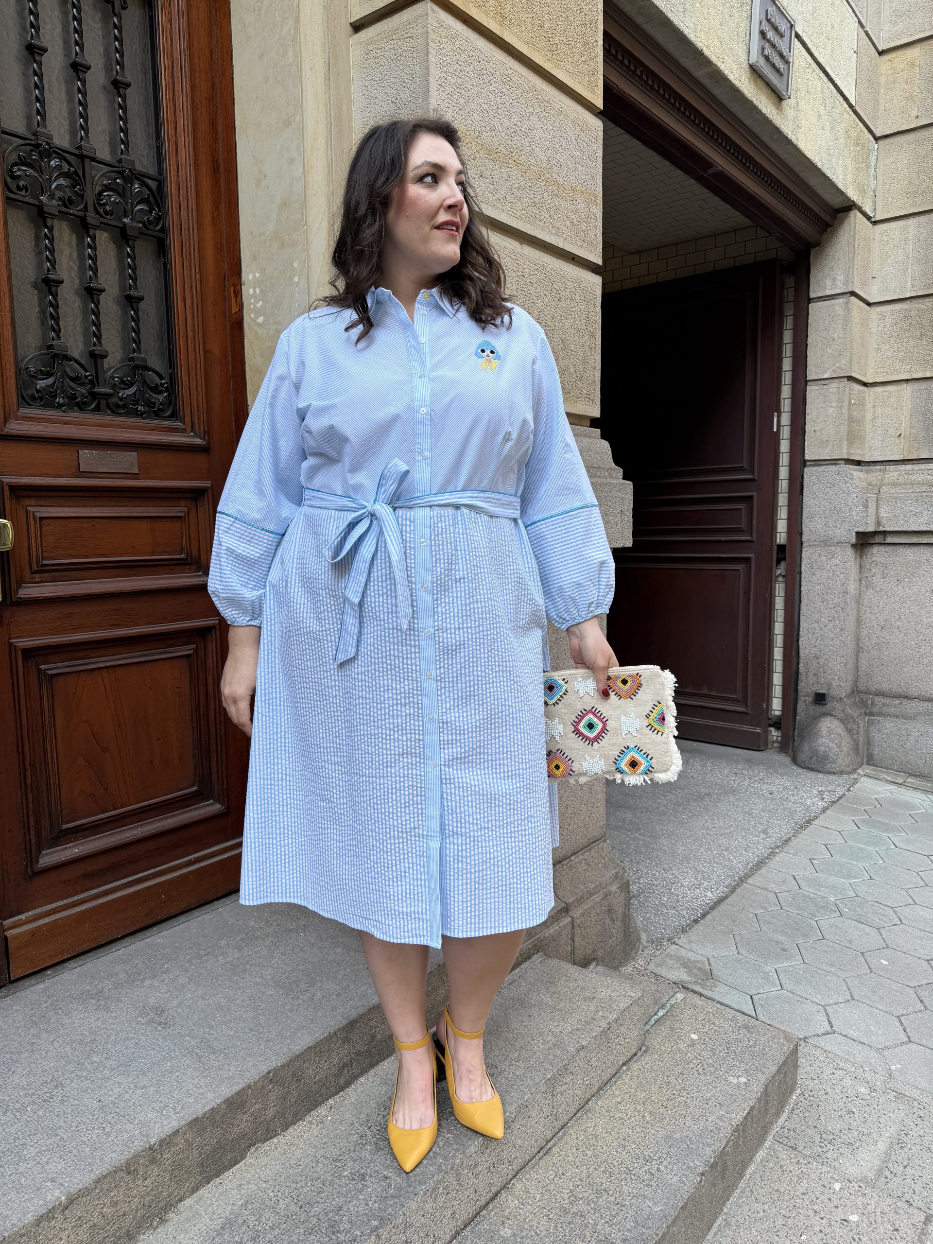 Hellblaues Hemdblusenkleid mit Bindegürtel und gelben Pumps im Kurvenhaus Hamburg, Übergrößen Augsburg und Mode für mollige Frauen aus dem Süden mit Stil.
