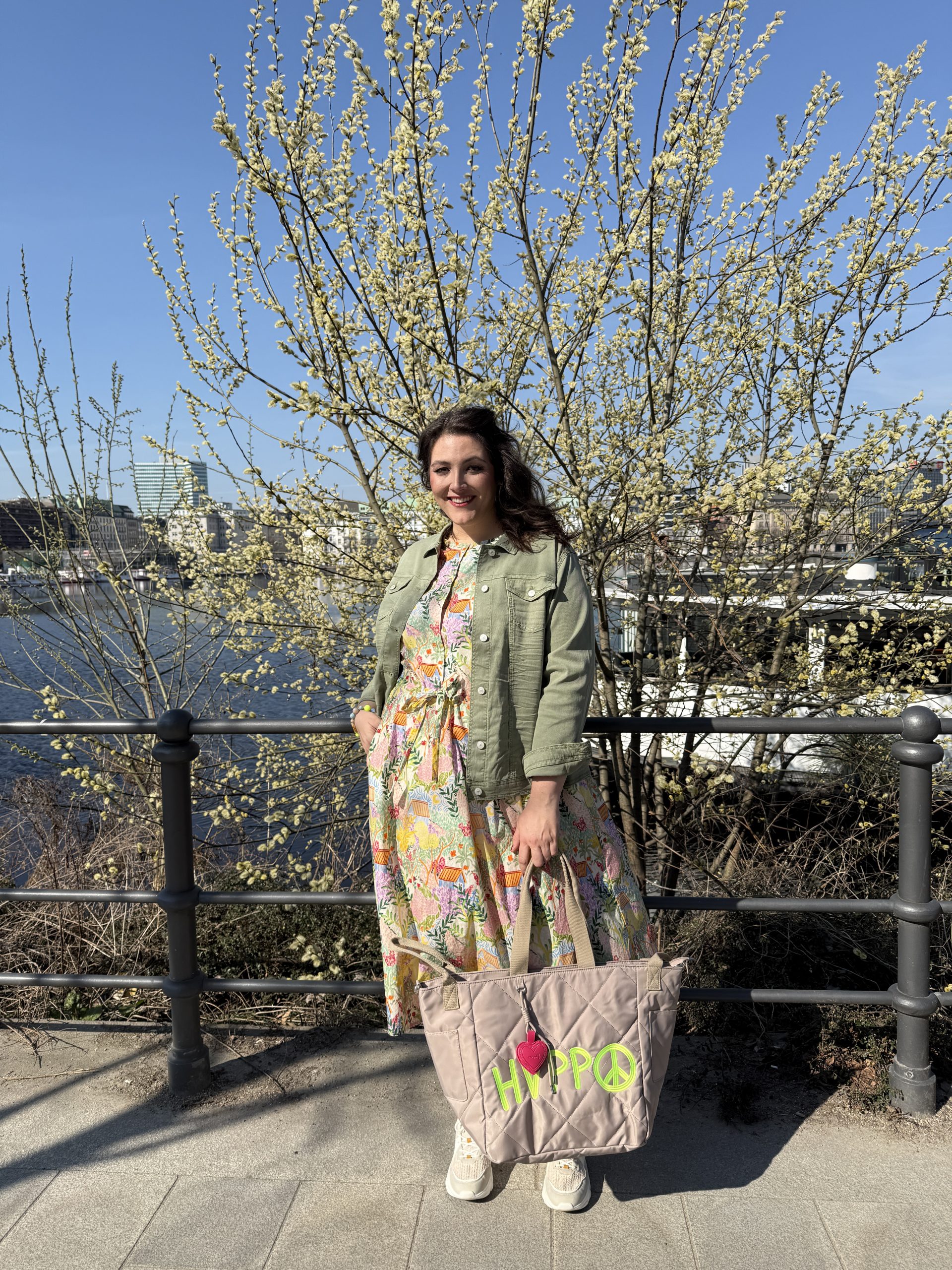 Kundin im Frühlingsoutfit mit Jeansjacke und floralem Maxikleid, große Größen Lüneburg im Kurvenhaus